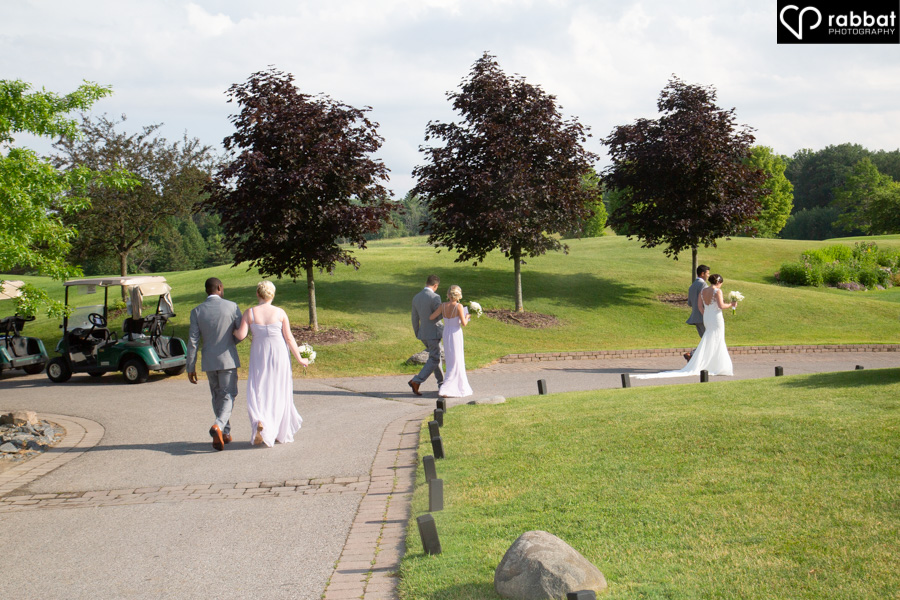 Bridal party walking away from the ceremony at King Riding Golf Club