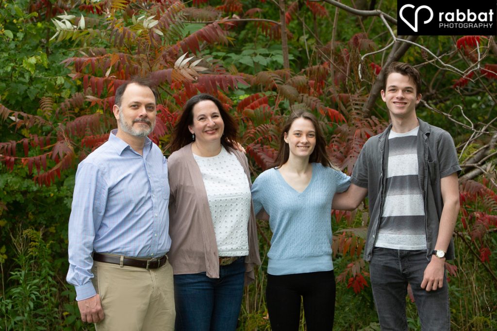 Family of four in front of sumac tree