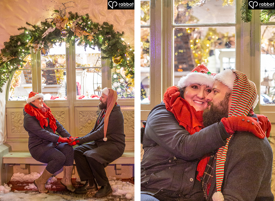 Engagement Photos in front of Christmas windows. Couple on bench under Christmas arch outside of store.