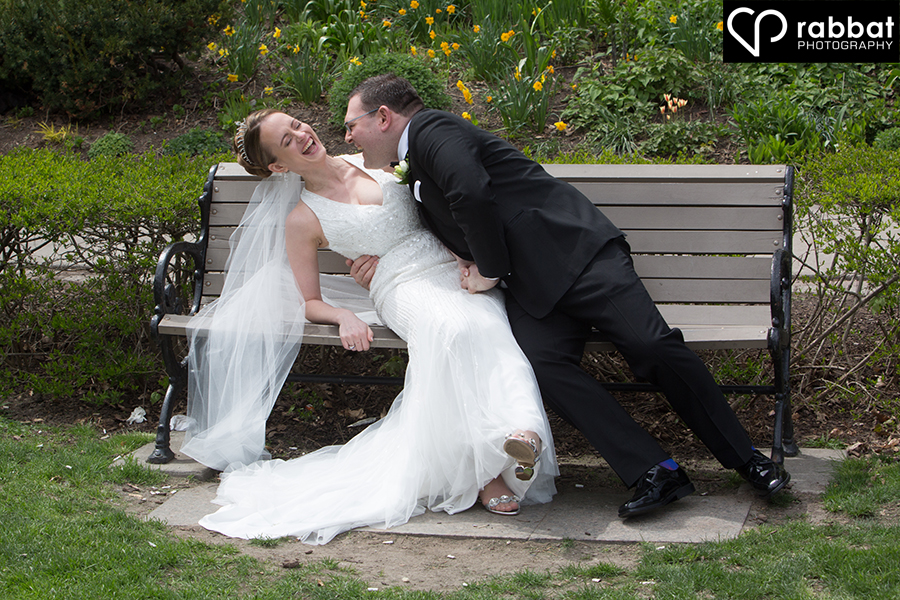 Wedding couple laughing on bench