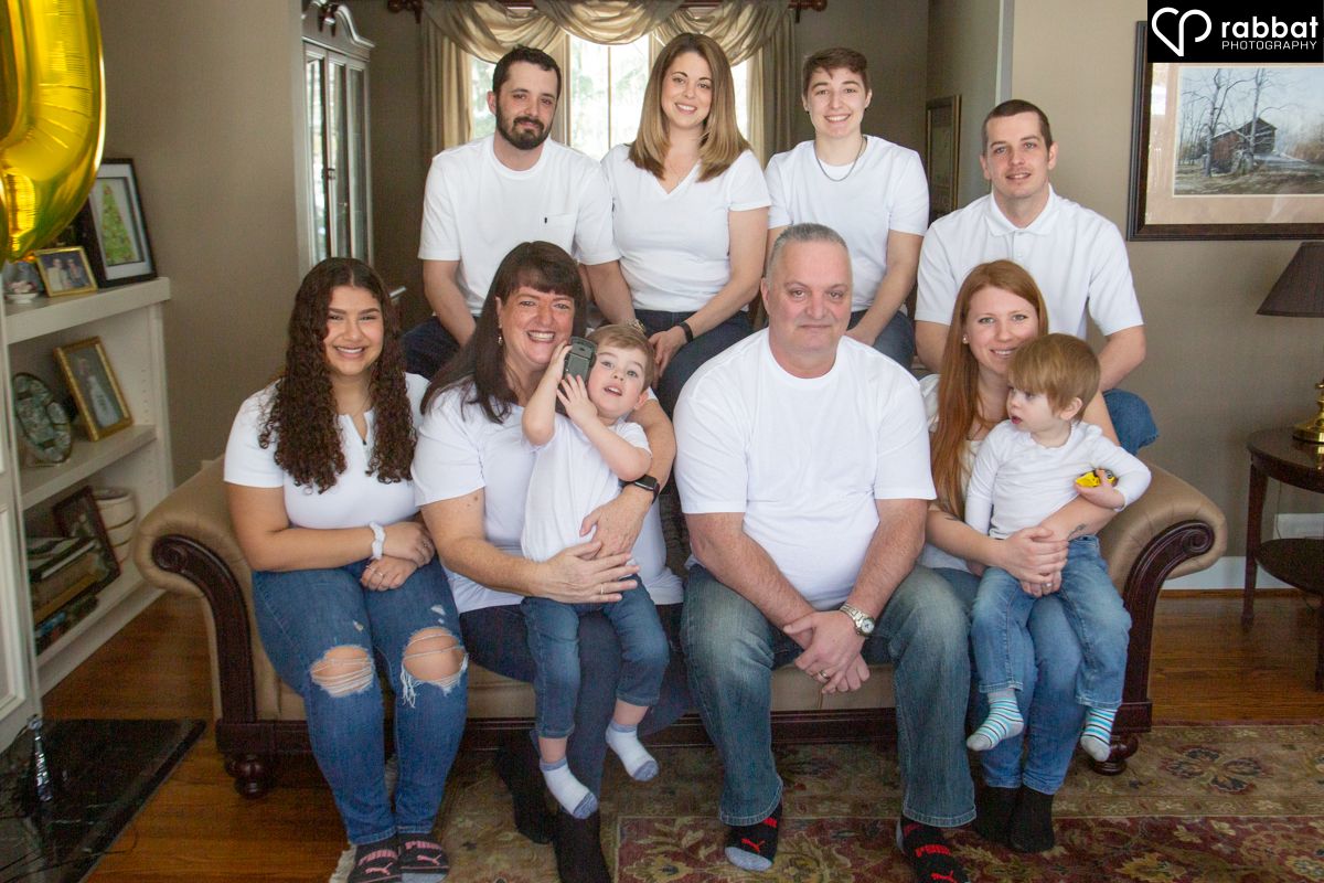 Large group family portrait of 10 people, all wearing white t-shirts. 