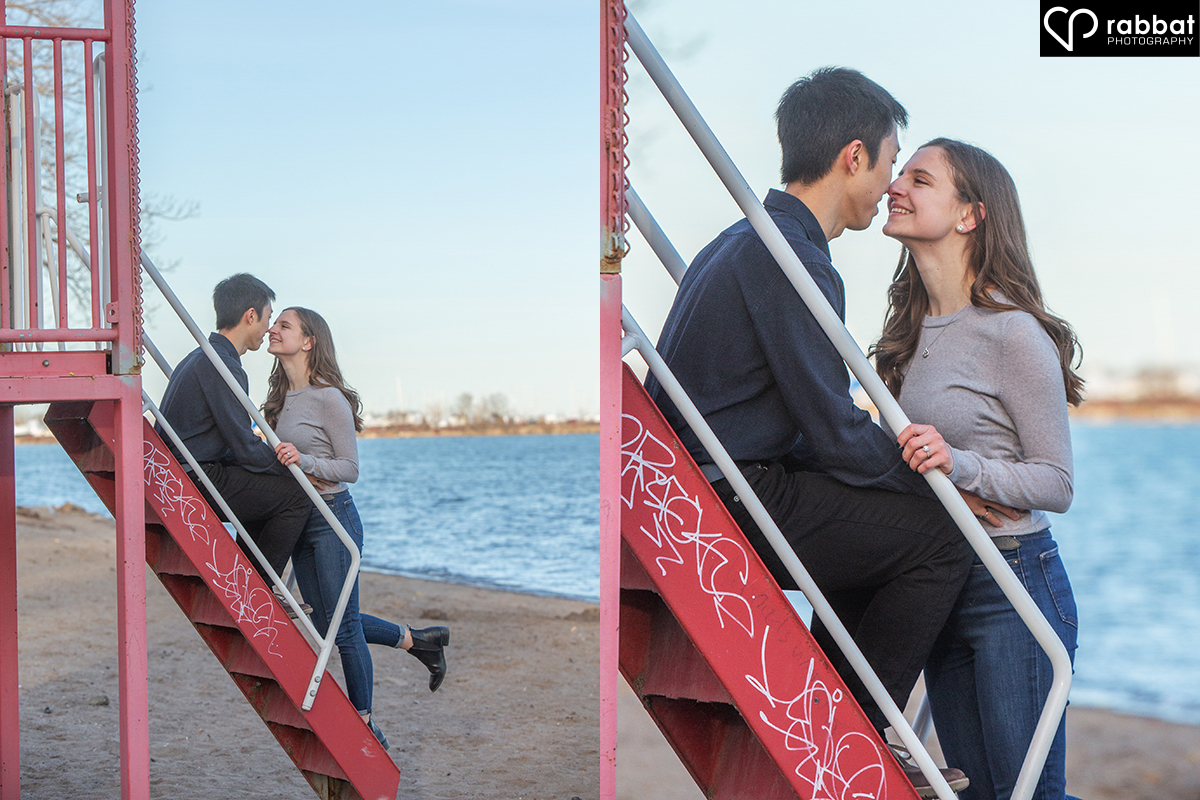 Couple kissing on red Toronto lifeguard stand with Lake Ontario and a blue sky in the background. Two side by side vertical photos. In the one on the left, you can see their full bodies. The photo on the right is a close-up.
