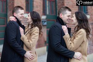Close-up side by side vertical photos of a man with short brown hair in a dark coat hugging a woman in a brown dressy coat. She has one arm around his neck and the other on his shoulder so her wedding ring is visible. She has long wavy brown hair. In the first photo, they are looking at each other and look like they are about to kiss. In the second, they are nose to nose and smiling at each other.