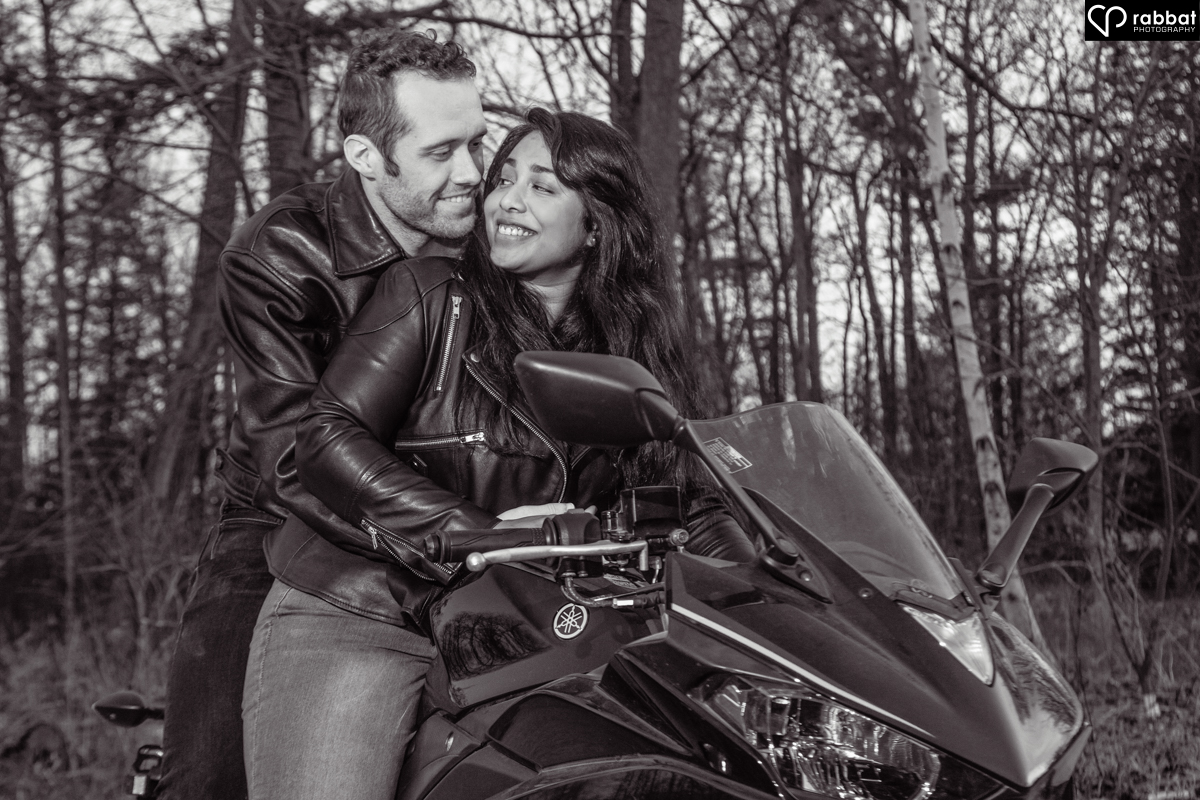 Black and white photo of a motorcyle riding couple, with the woman in the front.